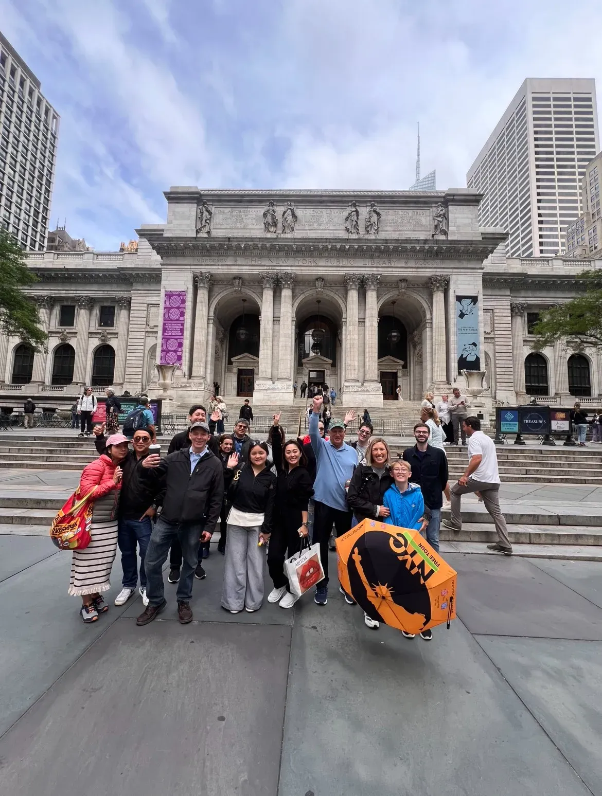 Group of people posing in front of a historic library building.